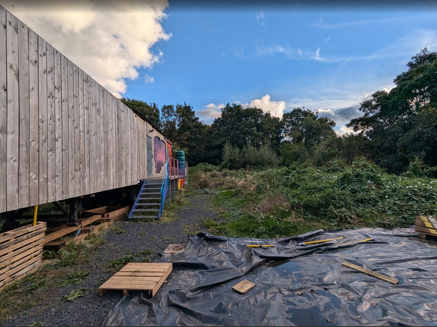 Greenacre before activation, with the site overgrown around the existing trailer