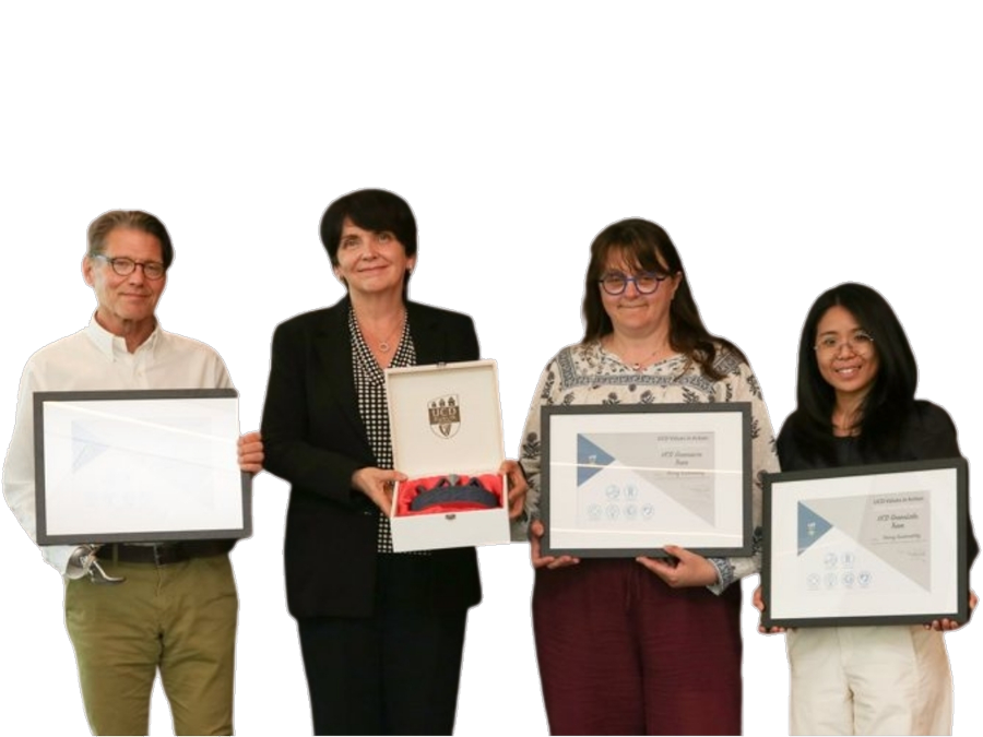 Four members of the Greenacre team holding framed UCD Values in Action
                 award certificates, with the President of UCD